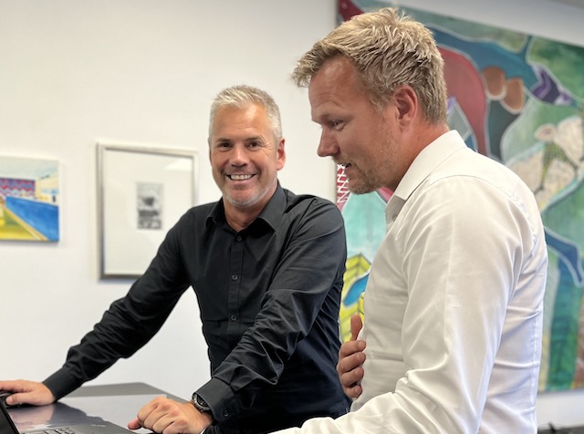 Two men looking at a laptop