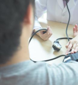 Doctor checking a man's blood pressure